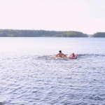Kaksi ihmistä uimassa järvessä